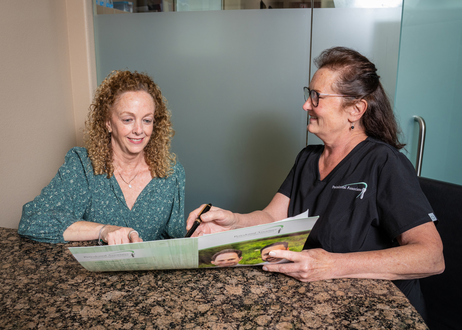 A dental assistant discusses payment options with a patient