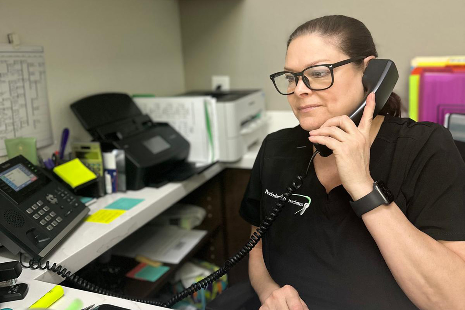 A dental assistant answering the phone