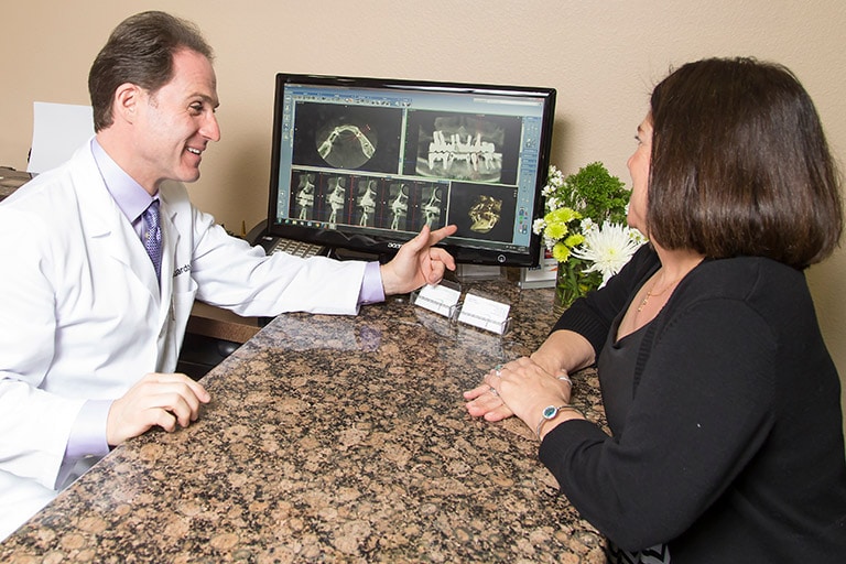 Image of Dr. Tanur speaking with a patient during a consultation about dental treatments.