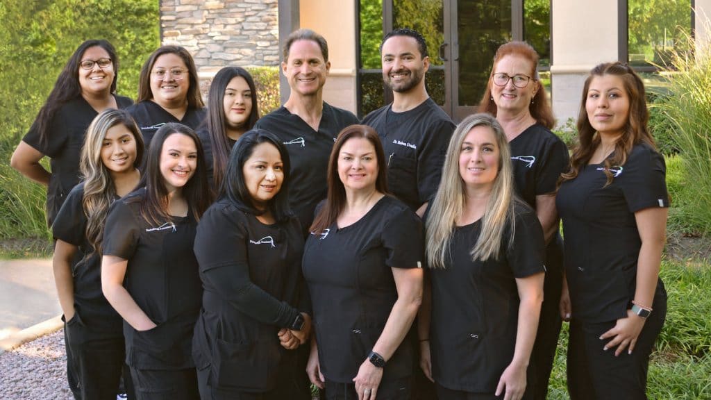 An image of the dental practice staff standing outside in a group arrangement.